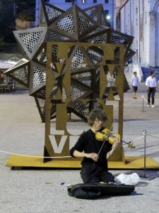 Pietrasanta, Piazza Duomo, un musicista di strada e un opera di Jan Fabre (2011) (foto Giorgio Pagano)